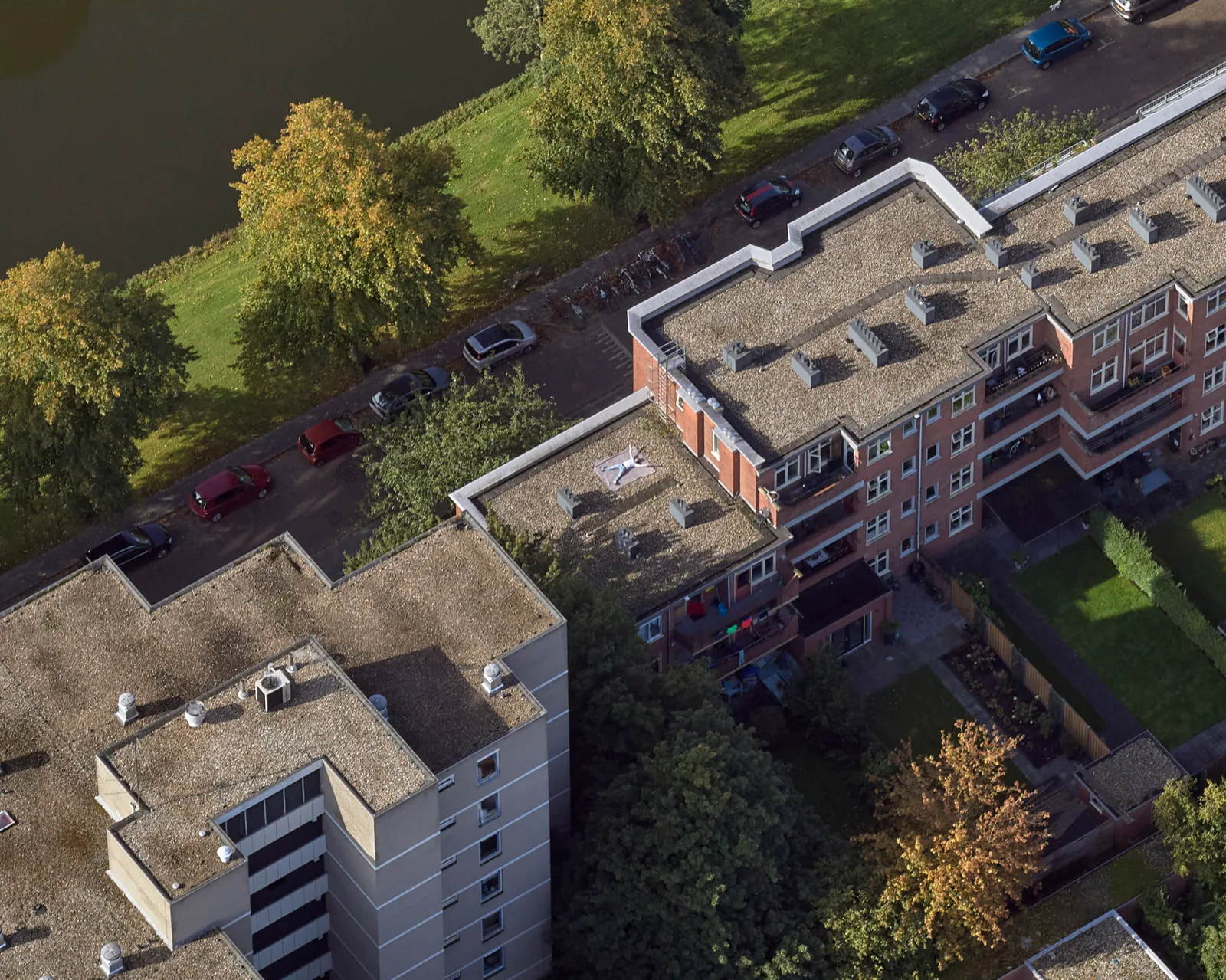 Oblieke luchtfoto 45° van een woonblok — gevels, daken en omgeving zichtbaar vanuit vier richtingen voor gevelinspectie